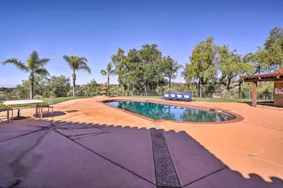 a swimming pool in the middle of a yard at Equestrian Estate with Horse Stables and Pool! in Valley Center
