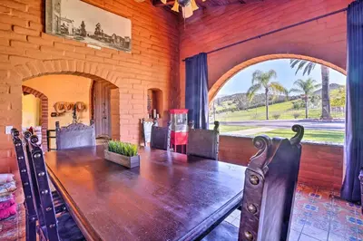 a dining room with a wooden table in a building at Equestrian Estate with Horse Stables and Pool! in Valley Center