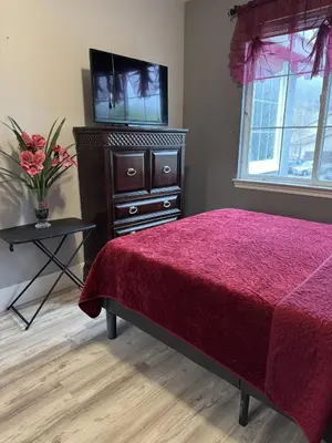 a bedroom with a bed and a dresser with a television at Beautiful City Lights and Mountain Views in Menifee