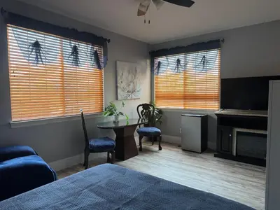 a bedroom with a bed and a table and two chairs at Beautiful City Lights and Mountain Views in Menifee