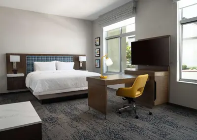 a hotel room with a bed and a desk and a television at Hampton Inn & Suites El Cajon San Diego in El Cajon