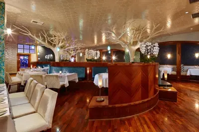 a restaurant with white tables and chairs and trees at Viejas Casino & Willows Hotel in Alpine