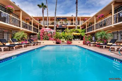 a swimming pool at a hotel with chairs and flowers at 14 West Laguna Beach in Laguna Beach