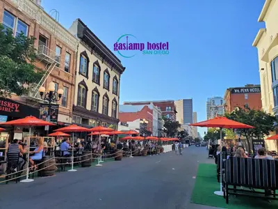 a street with tables and umbrellas on a city street at Gaslamp Hostel in San Diego