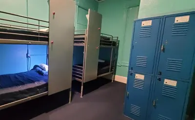 a room with two bunk beds and blue lockers at Gaslamp Hostel in San Diego