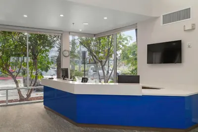 a lobby with a blue and white counter with a tv at Worldmark Oceanside Harbor in Oceanside