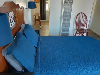 a bedroom with a blue bed and a chair at Oceana Boutique Hotel in San Clemente