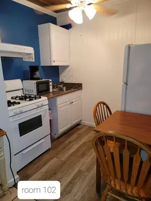 a kitchen with a white stove top oven next to a table at Oceana Boutique Hotel in San Clemente