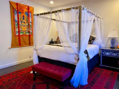 a bedroom with a canopy bed with a red bench at Quiet Mind Mountain Lodge, Retreat & Spa in Julian