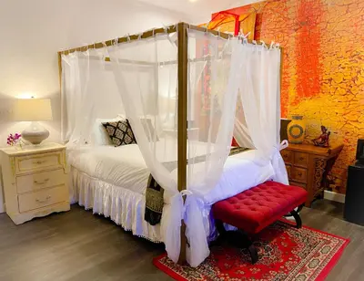 a bedroom with a canopy bed with a red bench at Quiet Mind Mountain Lodge, Retreat & Spa in Julian