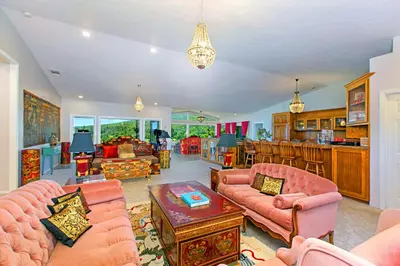 a living room with pink furniture and a kitchen at Quiet Mind Mountain Lodge, Retreat & Spa in Julian