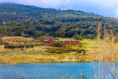 a red train on a hill next to a river at Quiet Mind Mountain Lodge, Retreat & Spa in Julian