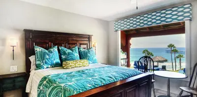 a bedroom with a bed with a view of the beach at Beachcomber Inn in San Clemente