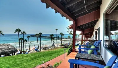 a porch with blue chairs and a view of the beach at Beachcomber Inn in San Clemente