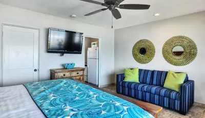 a living room with a blue couch and a tv at Beachcomber Inn in San Clemente