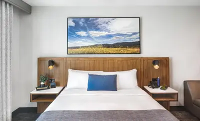 a bedroom with a large bed with a blue pillow at Ayres Hotel Vista Carlsbad in Vista