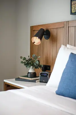 a bedroom with a bed with a clock and a lamp at Ayres Hotel Vista Carlsbad in Vista