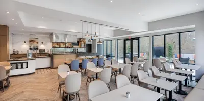 a restaurant with tables and chairs and a kitchen at Ayres Hotel Vista Carlsbad in Vista