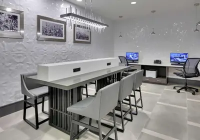 a kitchen with a large white counter and chairs at Hampton Inn by Hilton Irvine Spectrum Lake Forest in Lake Forest