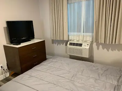 a bedroom with a bed and a television and a window at Solis Place in Old Town in San Diego