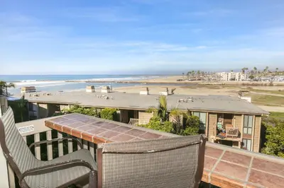 a balcony with two chairs and a view of the beach at E201 - Tropical Shores in Oceanside