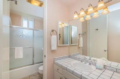 a bathroom with a sink and a toilet and a mirror at G218 - Palms Away in Oceanside