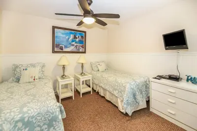 a bedroom with two beds and a flat screen tv at G218 - Palms Away in Oceanside