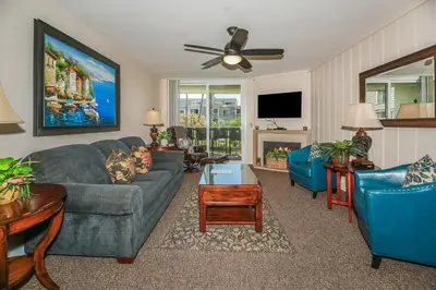 a living room with a couch and chairs and a tv at G218 - Palms Away in Oceanside