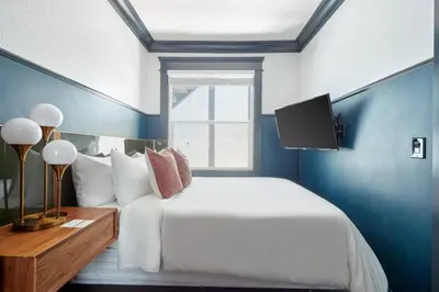 a bedroom with a white bed and a blue wall at The Davis Downtown San Diego in San Diego