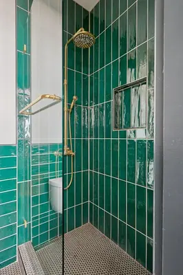 a bathroom with green tiled walls and a shower at The Davis Downtown San Diego in San Diego