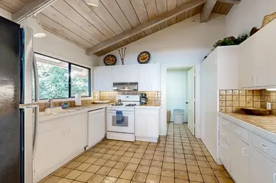 a kitchen with white cabinets and a tile floor at Forever Views in San Diego