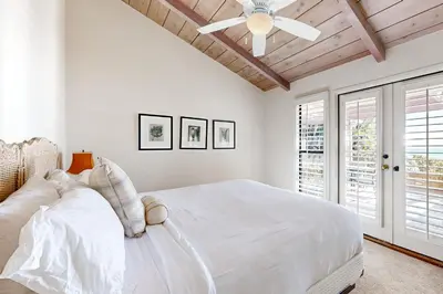 a white bedroom with a ceiling fan and a bed at Forever Views in San Diego