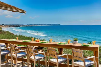 a long table with chairs and a view of the ocean at Forever Views in San Diego