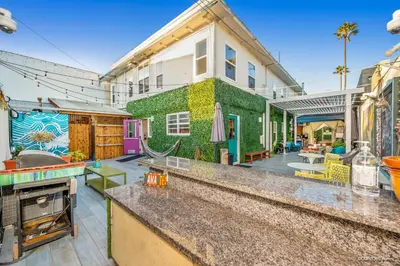 a house with a green wall with a backyard at Samesun Ocean Beach Hotel & Hostel in San Diego