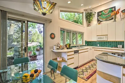 a kitchen with white cabinets and green accents at Luxe El Cajon Oasis with Pool, Fire Pit and Pavilion in El Cajon
