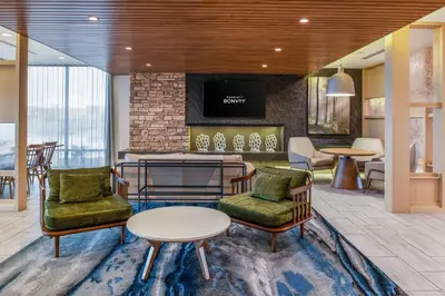 a lobby with chairs tables and a fireplace at Fairfield Inn & Suites by Marriott Menifee in Menifee