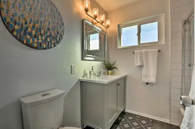 a bathroom with a toilet and a sink and a mirror at Oceanside Home with Patio and Grill, Walk to Beach! in Oceanside
