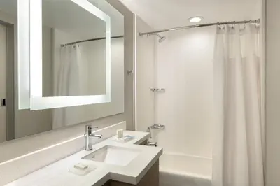 a white bathroom with a sink and a mirror at SpringHill Suites by Marriott San Diego Carlsbad in Carlsbad