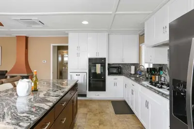 a kitchen with white cabinets and a black refrigerator at 128 Agate in Newport Beach