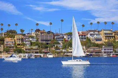 a sail boat in a body of water with buildings at 128 Agate in Newport Beach