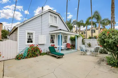 a white house with a patio and a table at 1106 Park Avenue in Newport Beach