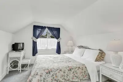 a white bedroom with a bed and a window at 201 Amethyst Avenue in Newport Beach