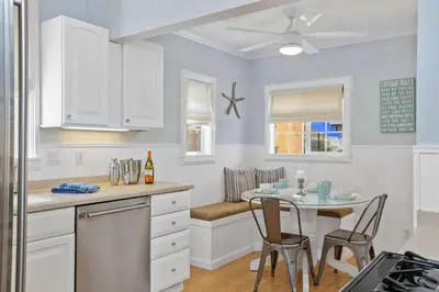 a kitchen with white cabinets and a table with chairs at 307 Thirty Fifth Street in Newport Beach