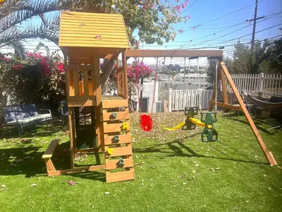 a wooden playset in a yard with a playground at Casita San Diego in San Diego