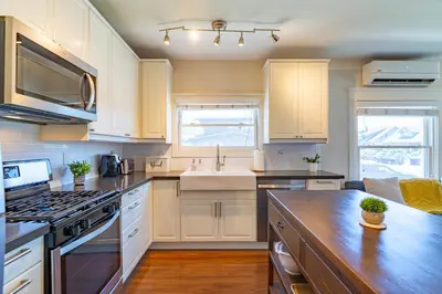 a kitchen with white cabinets and a counter top at Fern House South Park Craftsman in San Diego