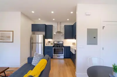 a kitchen with blue cabinets and a blue couch at Fern House South Park Craftsman in San Diego