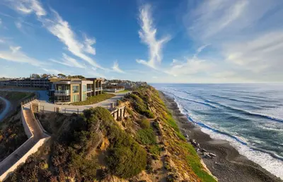 an aerial view of a house on a cliff next to the ocean at Alila Marea Beach Resort Encinitas, a Hyatt Resort in Encinitas