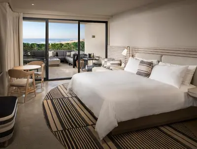 a bedroom with a large bed and a living room at Alila Marea Beach Resort Encinitas, a Hyatt Resort in Encinitas