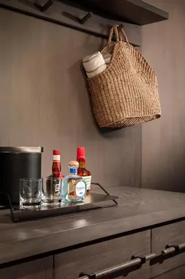 a counter with two bottles of sauce and a basket at Alila Marea Beach Resort Encinitas, a Hyatt Resort in Encinitas