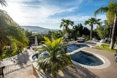 a backyard with a swimming pool and palm trees at Buena Creek Vista Primary Subdivided Home with Views and Pool in San Marcos